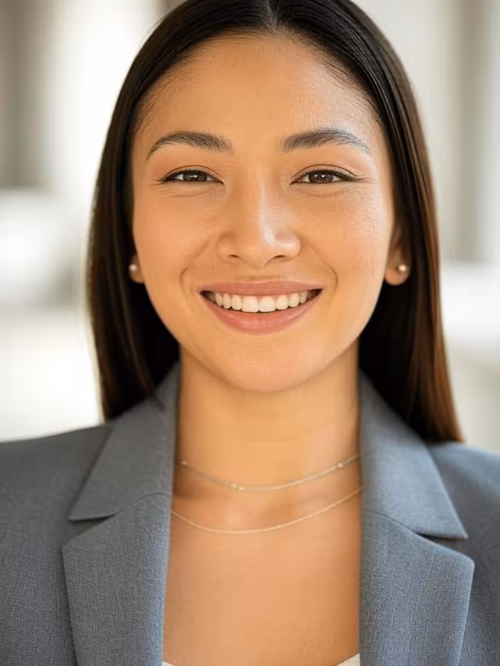 Professional headshot of confident young woman in her late twenties, stylish blazer, subtle luxury j