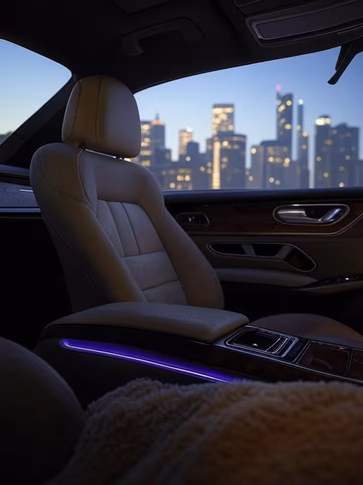 Sleek luxury car interior detail with city skyline visible through window at dusk, automotive lifest