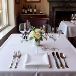 Fine Dining Etiquette for Sugar Babies: What Nobody Tells You About Cutlery, Napkins, and Not Looking Lost at Per Se elegant fine dining table setting with multiple pieces of silverware arranged on white linen tablecl