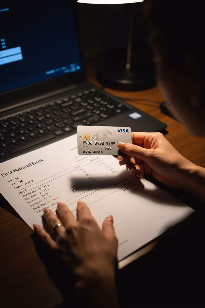 Close-up of hands protecting a credit card and bank statement, security and privacy theme, dark mood
